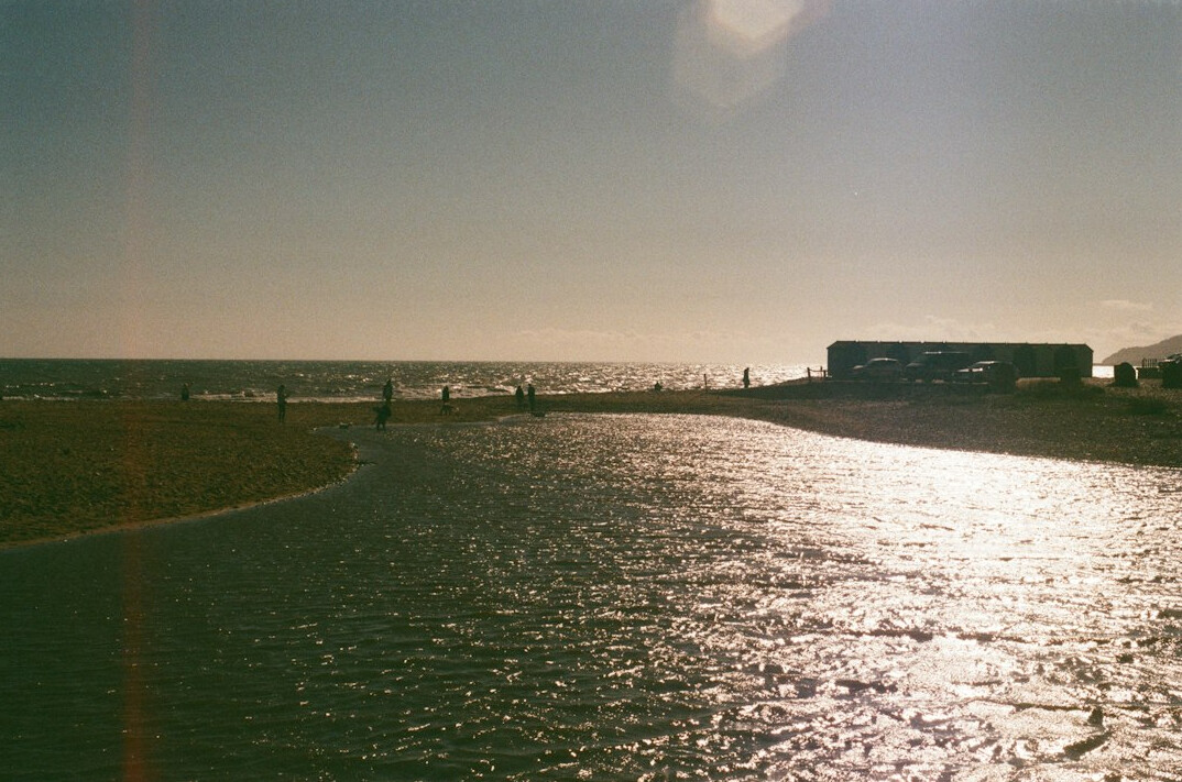 River mouth meeting the ocean with bridge silhouette