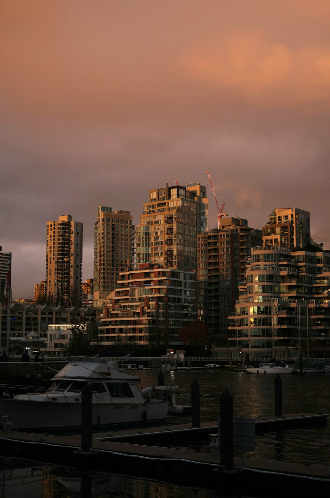 Marina with yachts and modern skyline at dusk